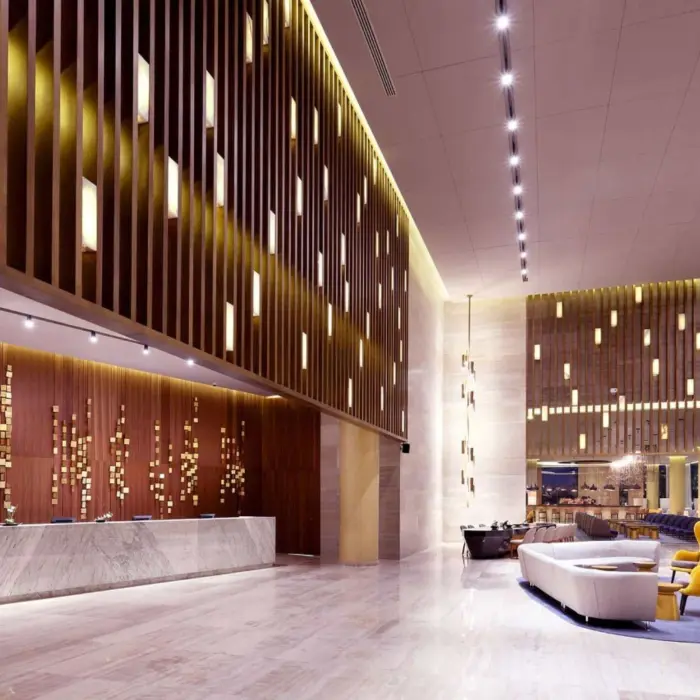 Resort lobby with high ceilings, wood panel accents, and cozy modern seating area.
