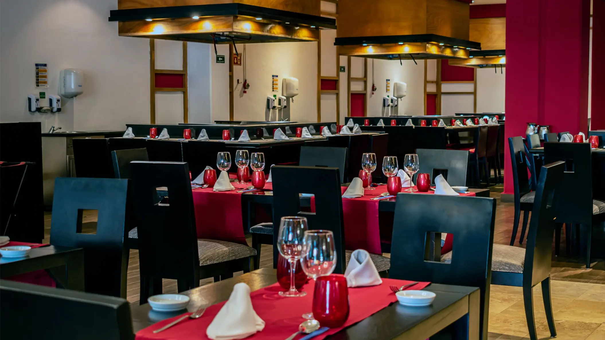 Interior of Grand Riviera Princess's Miso restaurant, set with dark tables, red accents, and Asian-inspired decor.