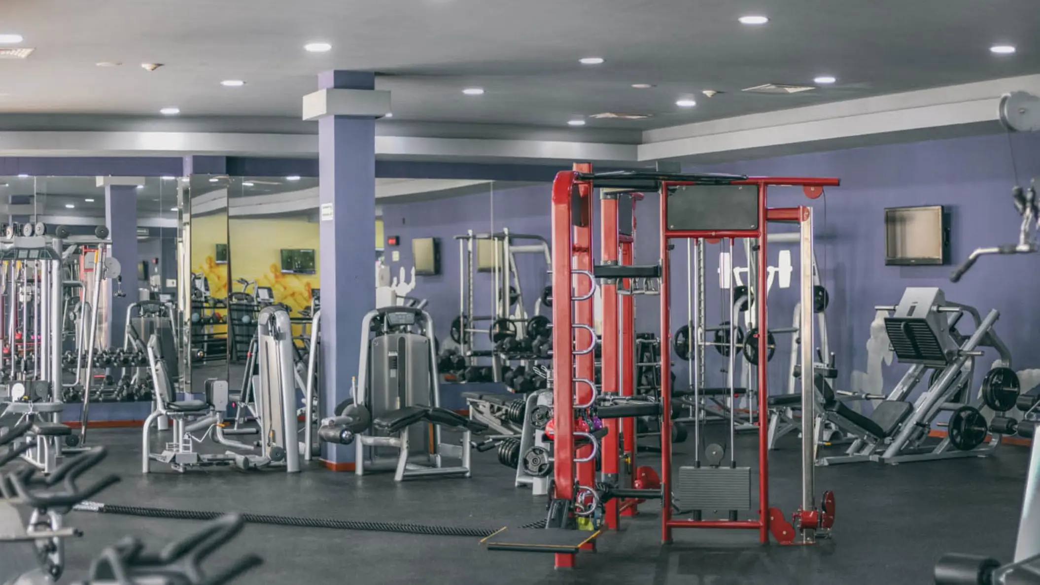 Well-equipped gym at Grand Riviera Princess with various modern exercise machines and mirrored walls.