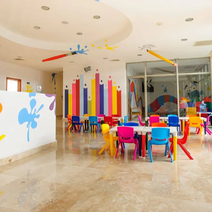 Vibrant kids' club at Grand Riviera Princess featuring colorful tables, chairs, and playful wall decorations.