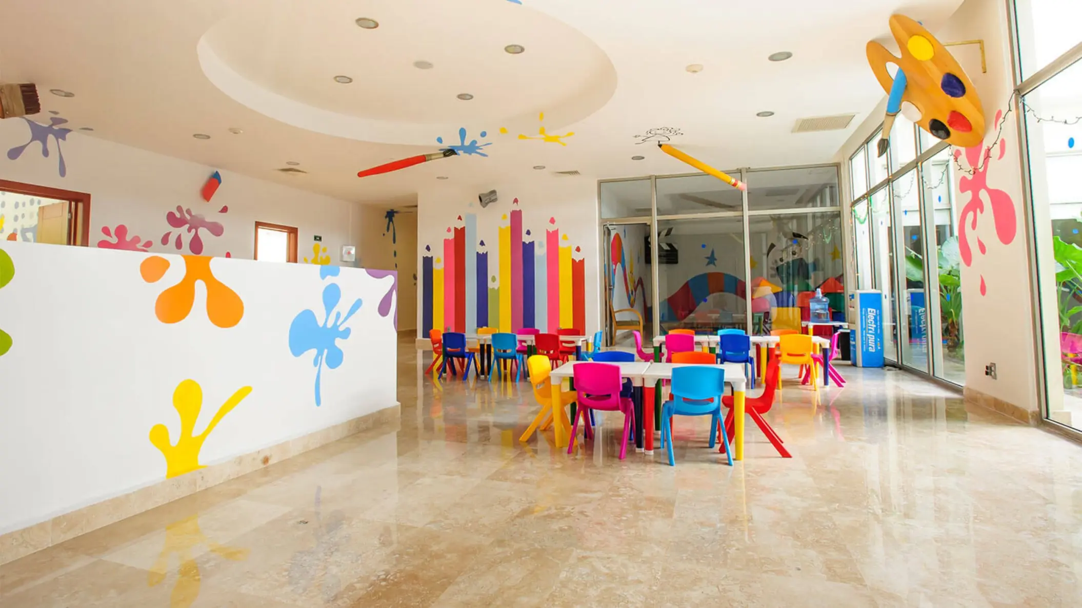 Vibrant kids' club at Grand Riviera Princess featuring colorful tables, chairs, and playful wall decorations.