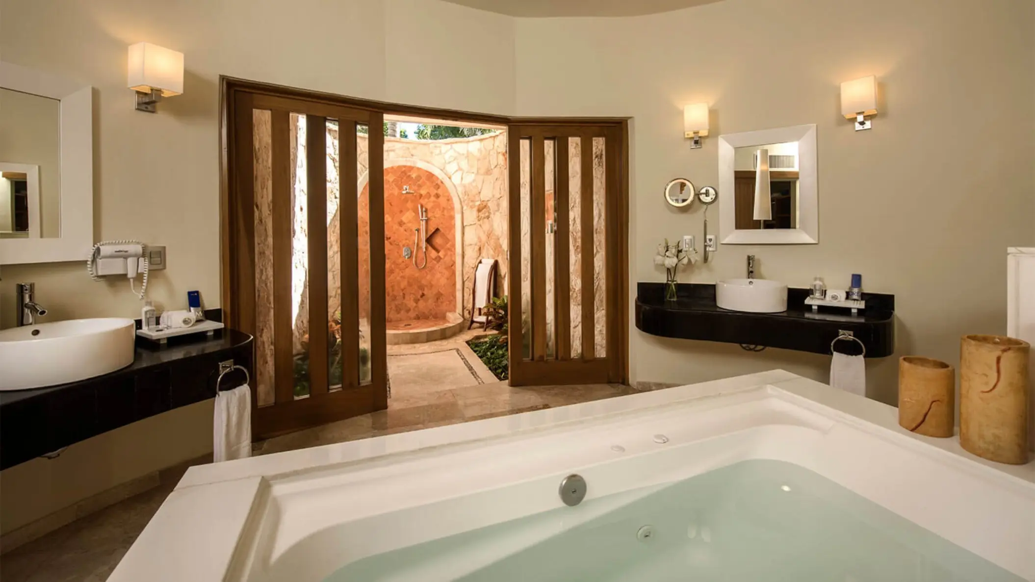 Luxurious Laguna Villa washroom featuring a large bathtub and an open-air stone shower.