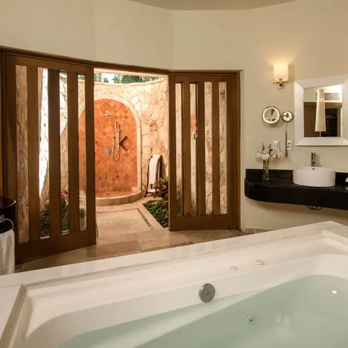 Luxurious Laguna Villa washroom featuring a large bathtub and an open-air stone shower.