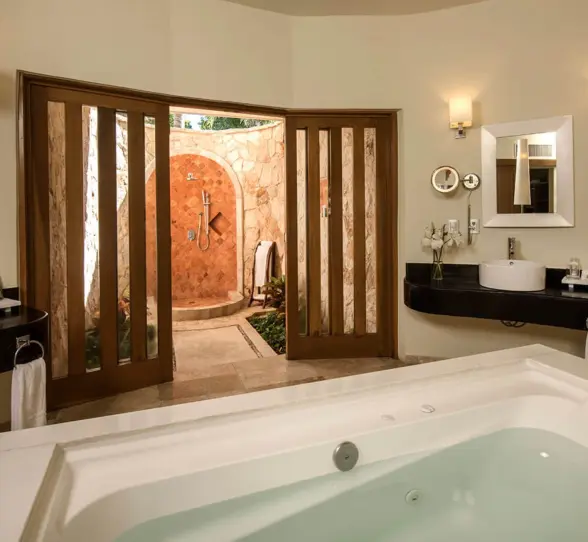 Luxurious Laguna Villa washroom featuring a large bathtub and an open-air stone shower.