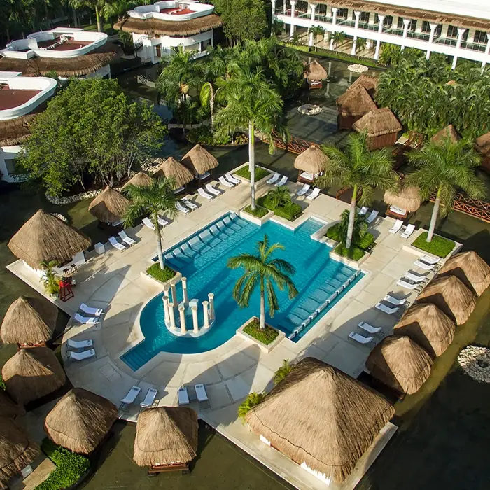 Overhead shot of Grand Sunset Princess resort's lush grounds, a large pool area with loungers, and tropical landscaping.