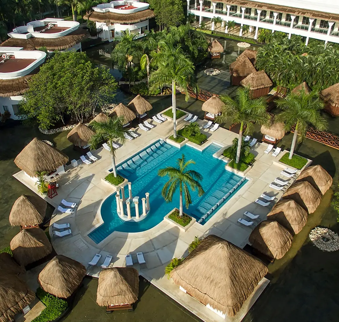 Overhead shot of Grand Sunset Princess resort's lush grounds, a large pool area with loungers, and tropical landscaping.