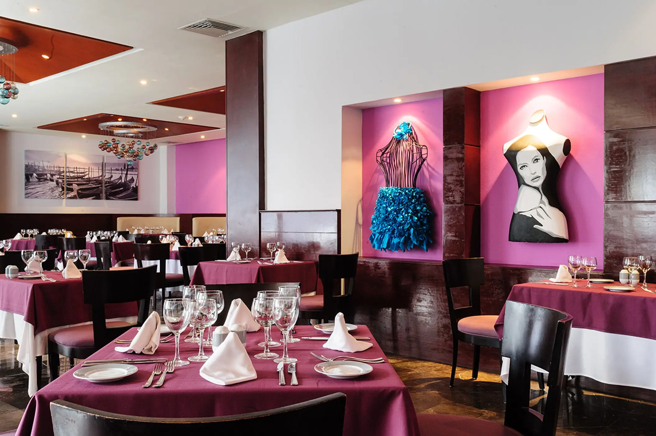 Italian restaurant at Grand Sunset Princess with elegantly set tables, purple accents, and unique artwork on the walls.