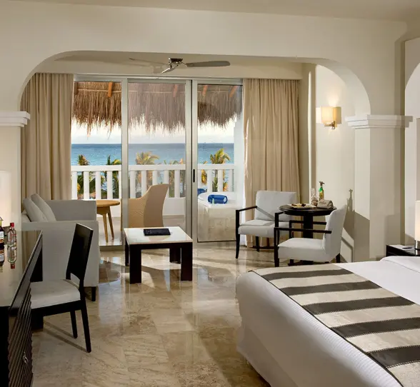 Luxurious oceanview suite at Grand Sunset Princess with a king bed, living area, and balcony overlooking the ocean.