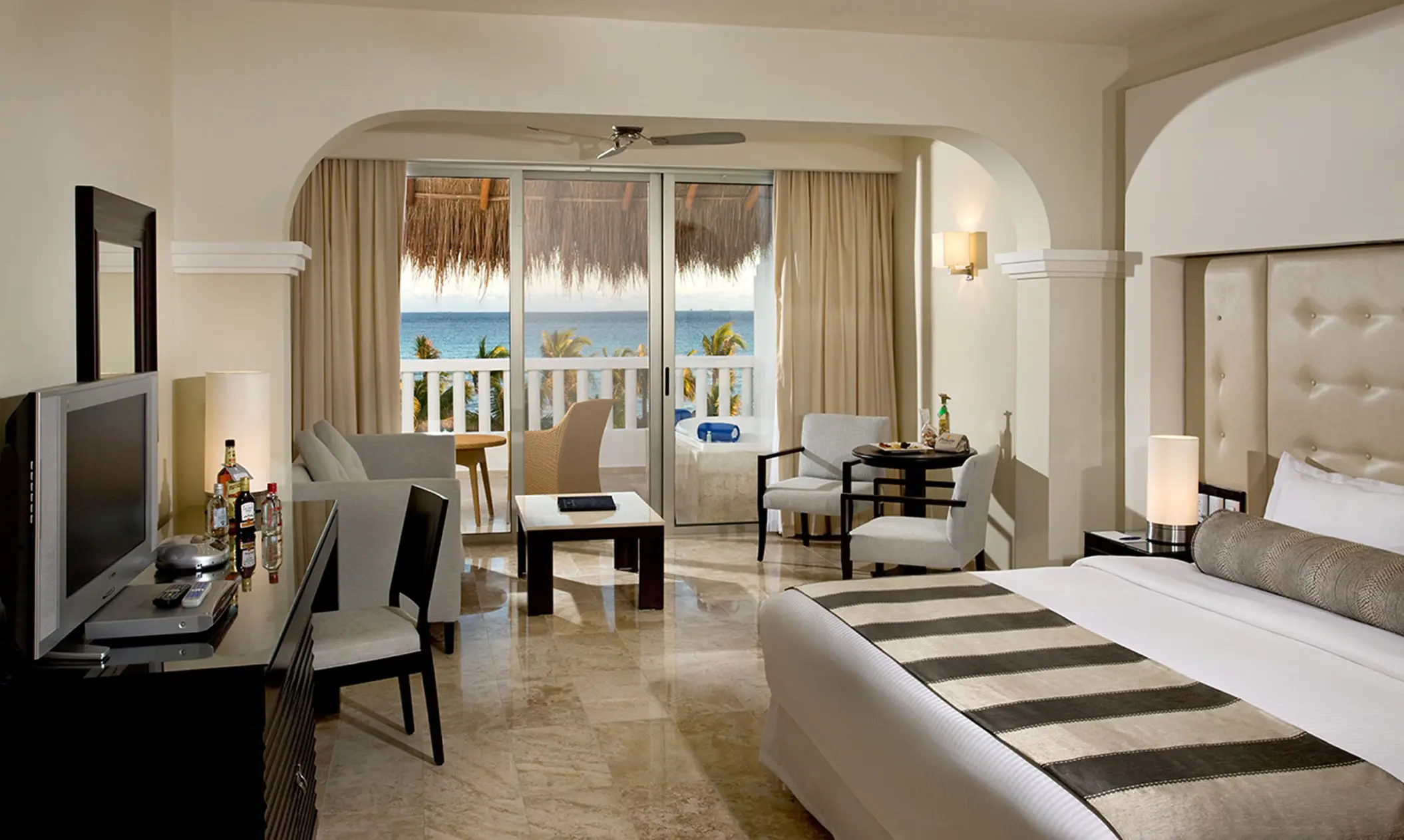 Luxurious oceanview suite at Grand Sunset Princess with a king bed, living area, and balcony overlooking the ocean.