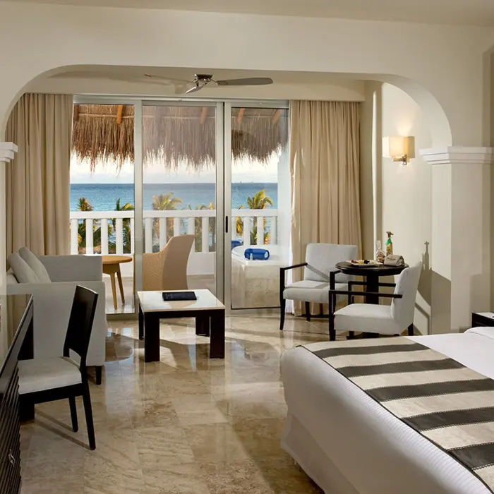 Luxurious oceanview suite at Grand Sunset Princess with a king bed, living area, and balcony overlooking the ocean.