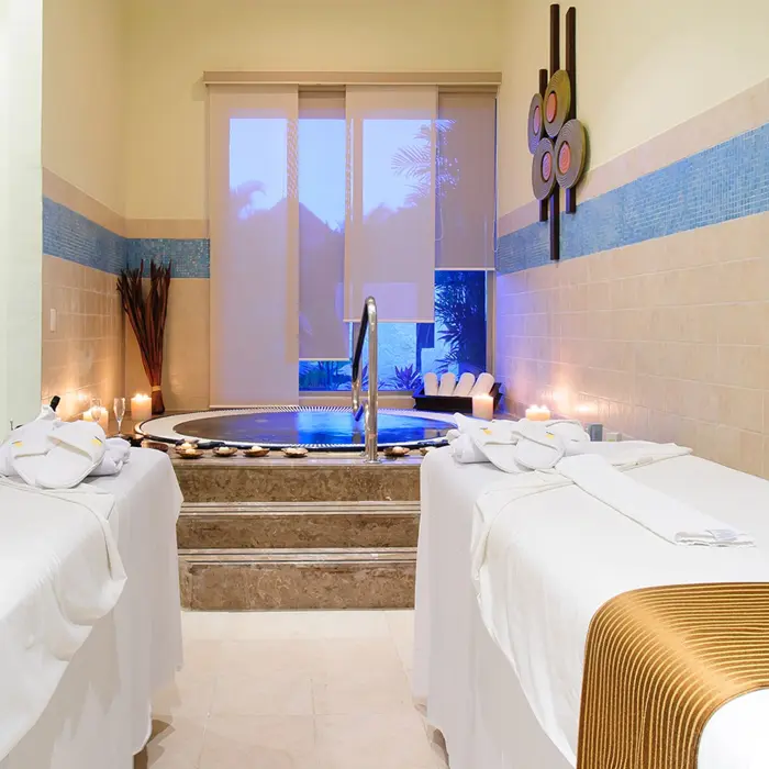 Tranquil spa at Grand Sunset Princess with two massage beds, a jacuzzi, and soft lighting for relaxation.