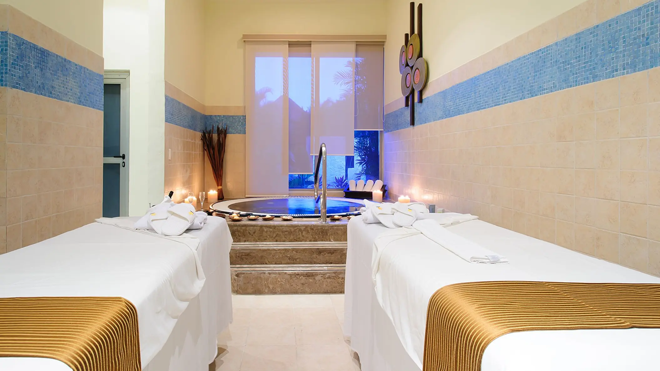 Tranquil spa at Grand Sunset Princess with two massage beds, a jacuzzi, and soft lighting for relaxation.