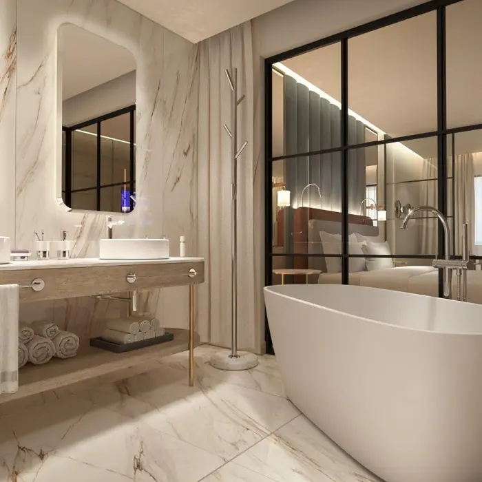 Modern bathroom at Grand Sunset Princess with marble walls, double vanity, free-standing tub, and glass wall to bedroom.