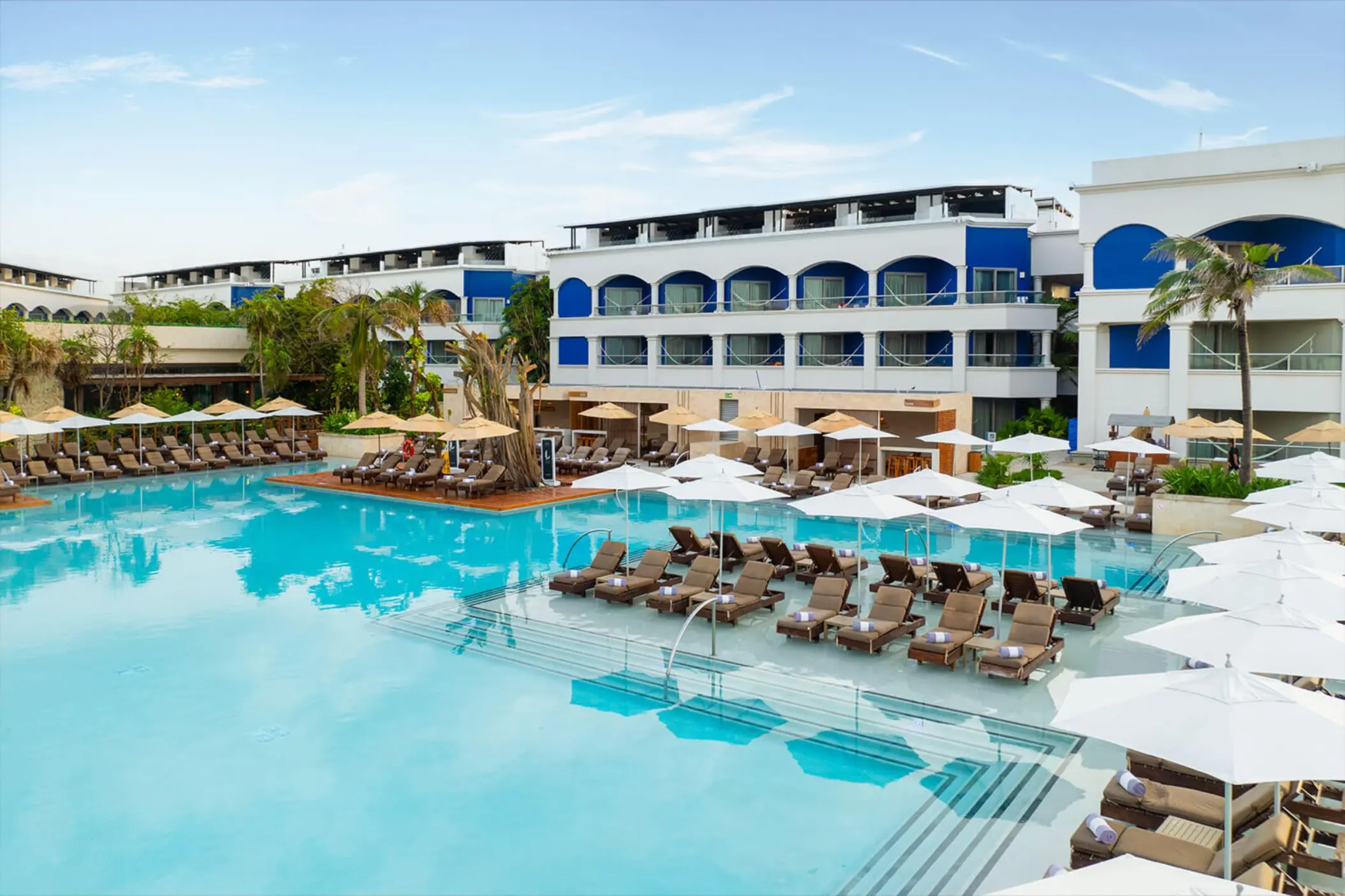 An expansive swimming pool lined with lounge chairs and umbrellas in the adults-only Heaven section.
