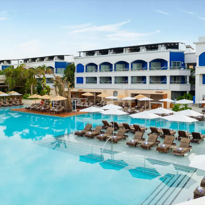 An expansive swimming pool lined with lounge chairs and umbrellas in the adults-only Heaven section.