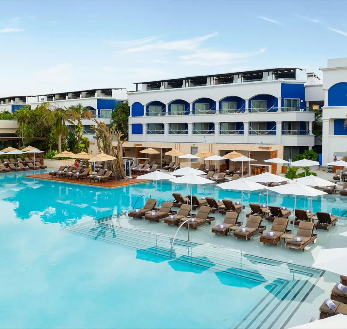 An expansive swimming pool lined with lounge chairs and umbrellas in the adults-only Heaven section.