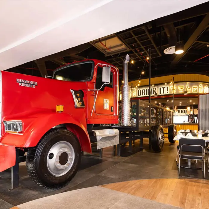 The interior of a modern restaurant featuring a full-sized red semi-truck as a centerpiece.