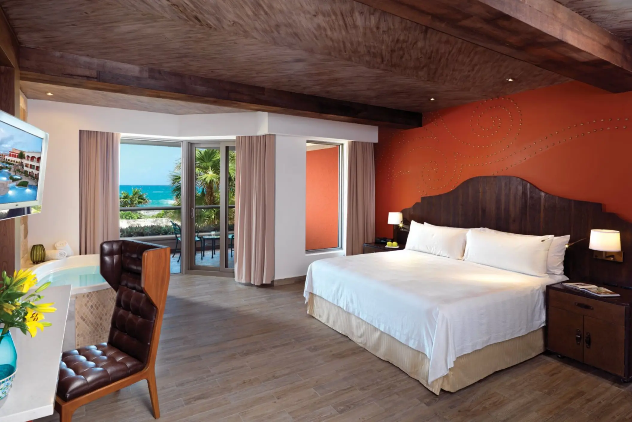 A spacious suite with a king bed, a balcony with an ocean view, and a jacuzzi tub.