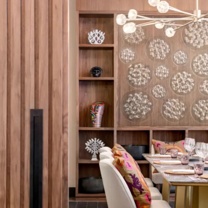 Private dining room with bold Mexican decor, colorful pillows, sculptural lighting, and custom wood shelving details.