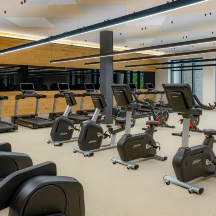 State-of-the-art fitness center with treadmills, spin bikes, and large mirrors reflecting a clean, modern design.