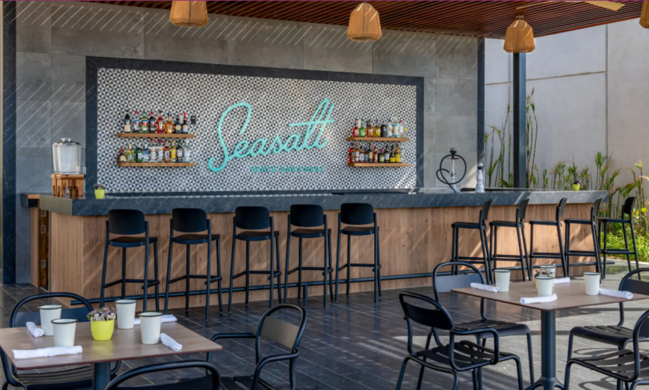 Outdoor Seasalt bar with modern seating, wood finishes, and a wide selection of premium spirits on display.