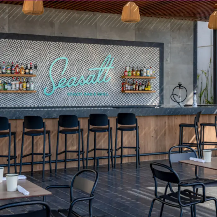 Outdoor Seasalt bar with modern seating, wood finishes, and a wide selection of premium spirits on display.