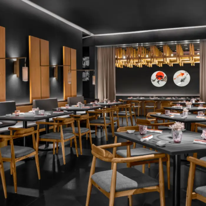 Contemporary black-and-wood Japanese restaurant with koi fish wall art and warm, ambient lighting.