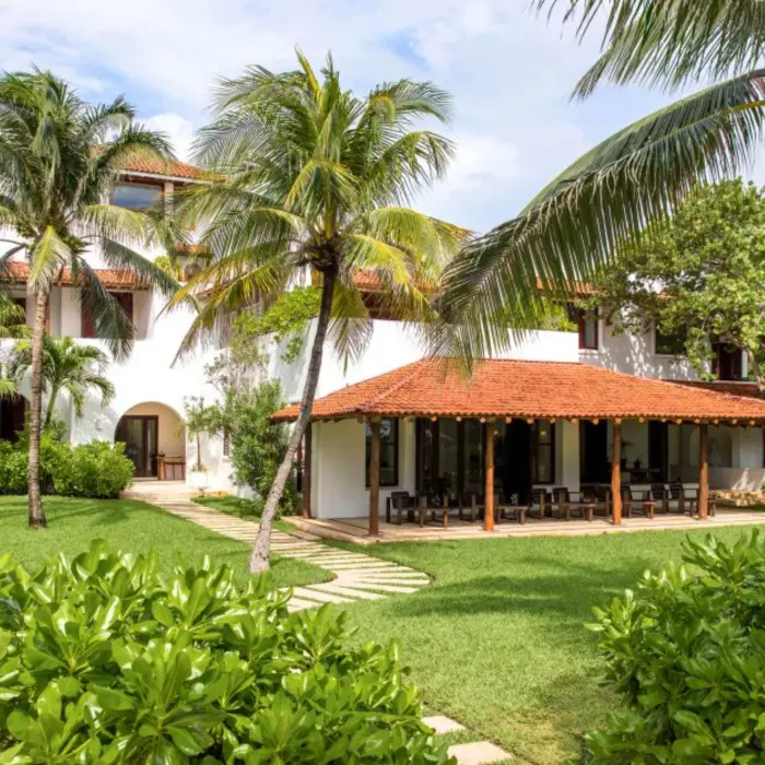 Hotel Esencia resort building surrounded by greenery