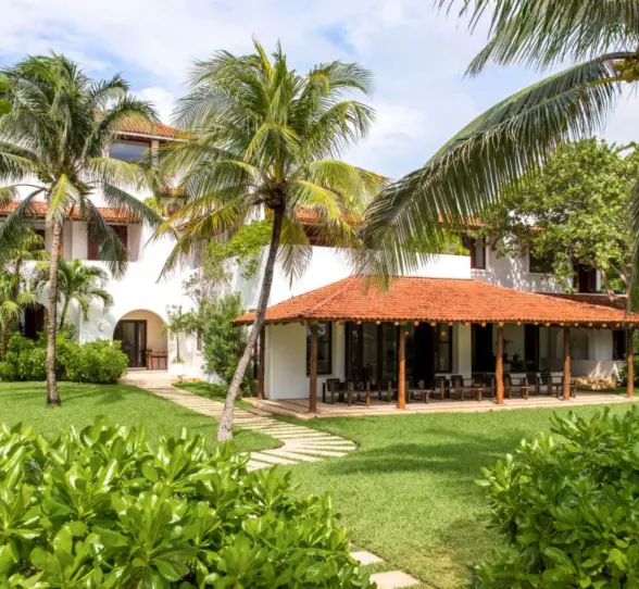 Hotel Esencia resort building surrounded by greenery