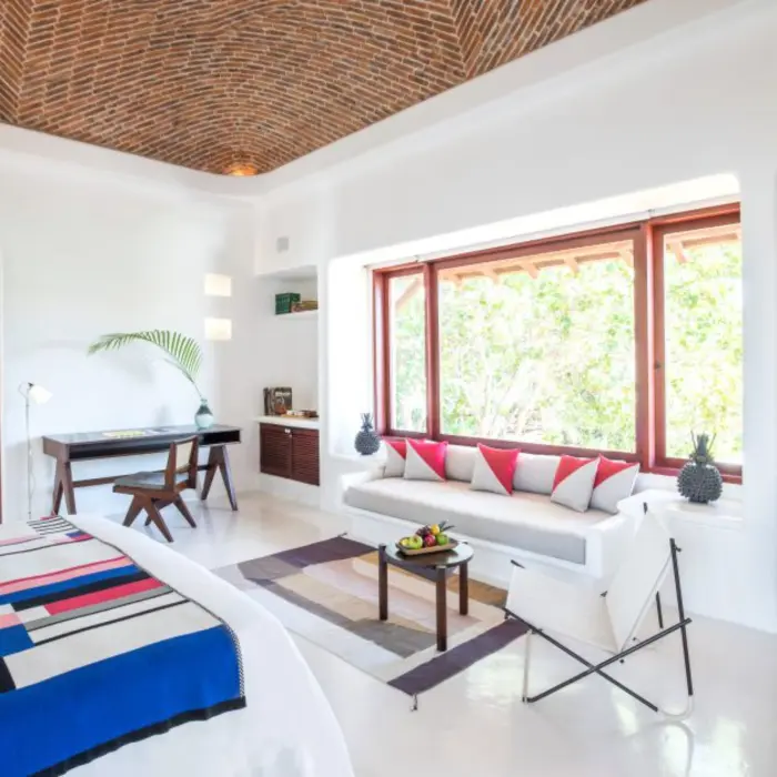 suite with double bed and lounging area at Hotel Esencia