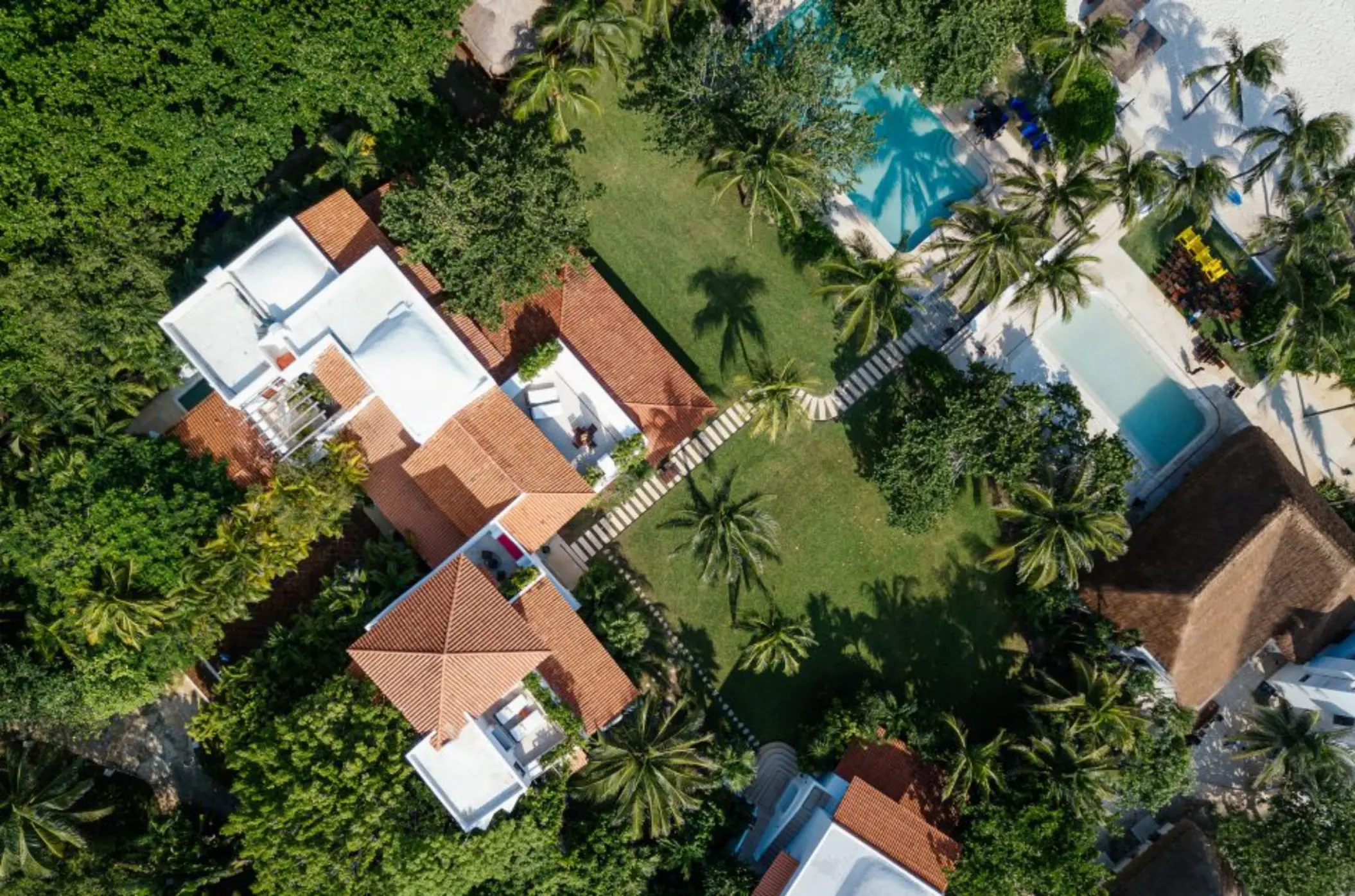 top view of Hotel Esencia with its buildings and pools and landscaped gardens