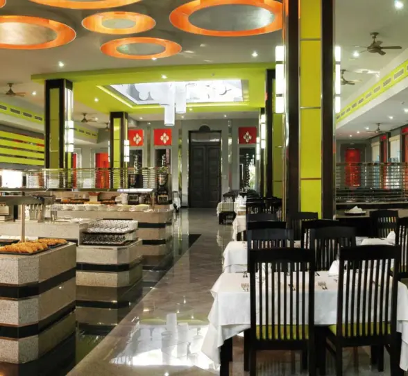 A spacious and modern buffet restaurant with a variety of food stations, ample seating, and bright yellow and white decor.