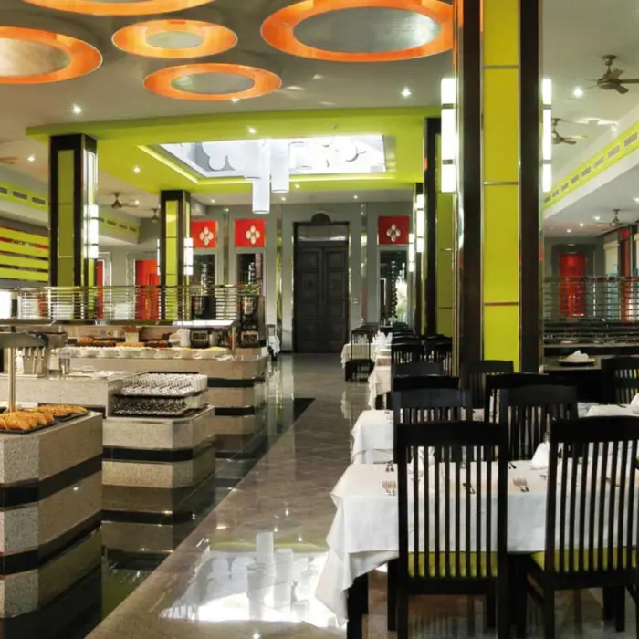 A spacious and modern buffet restaurant with a variety of food stations, ample seating, and bright yellow and white decor.