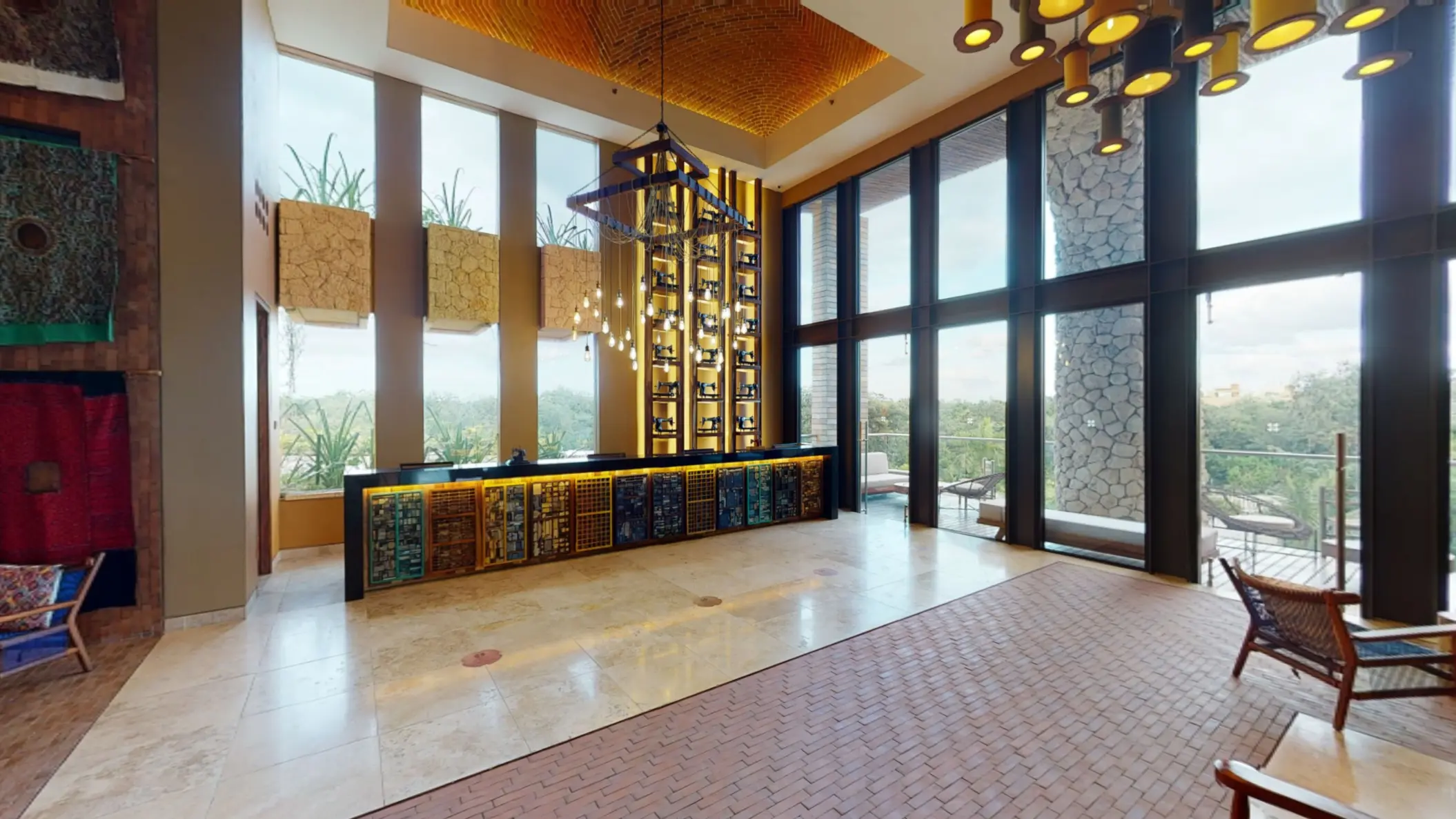Reception lobby with tall windows, modern hanging lights, and colorful design elements.