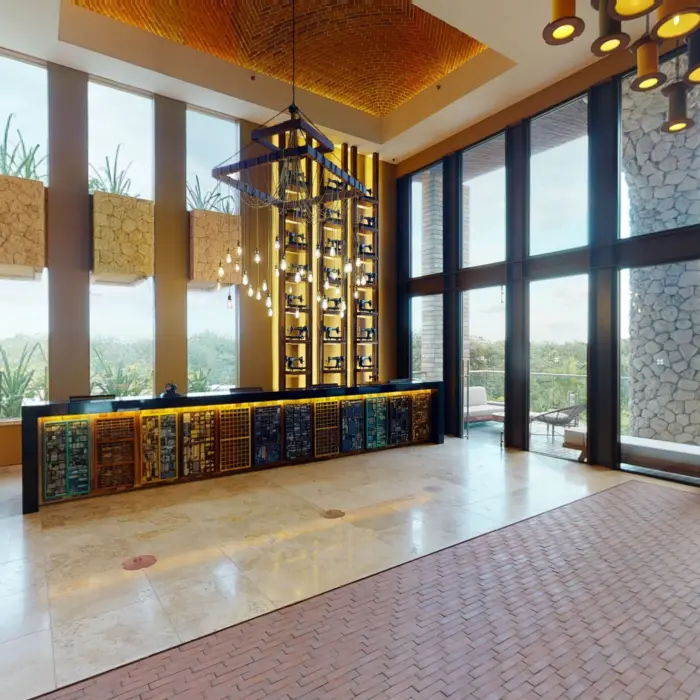Reception lobby with tall windows, modern hanging lights, and colorful design elements.