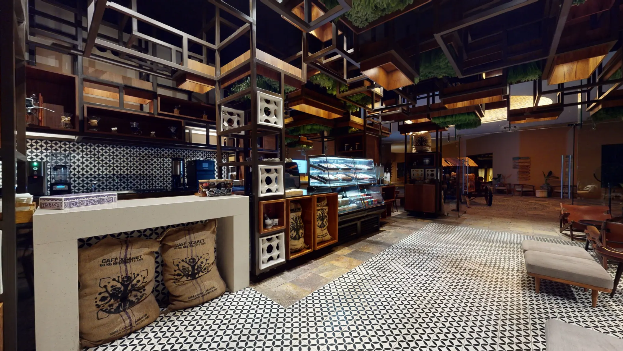 Cafeteca with patterned tile floors, artisanal coffee bags, and pastries displayed in a glass case.