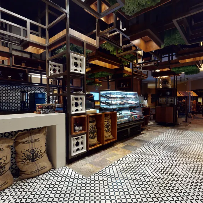 Cafeteca with patterned tile floors, artisanal coffee bags, and pastries displayed in a glass case.