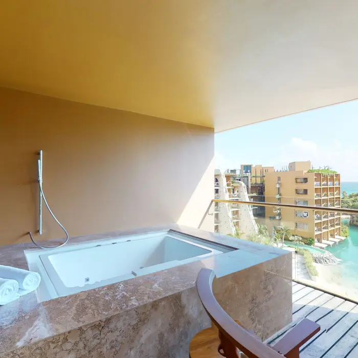 Outdoor jacuzzi on private terrace with sweeping river and ocean views.
