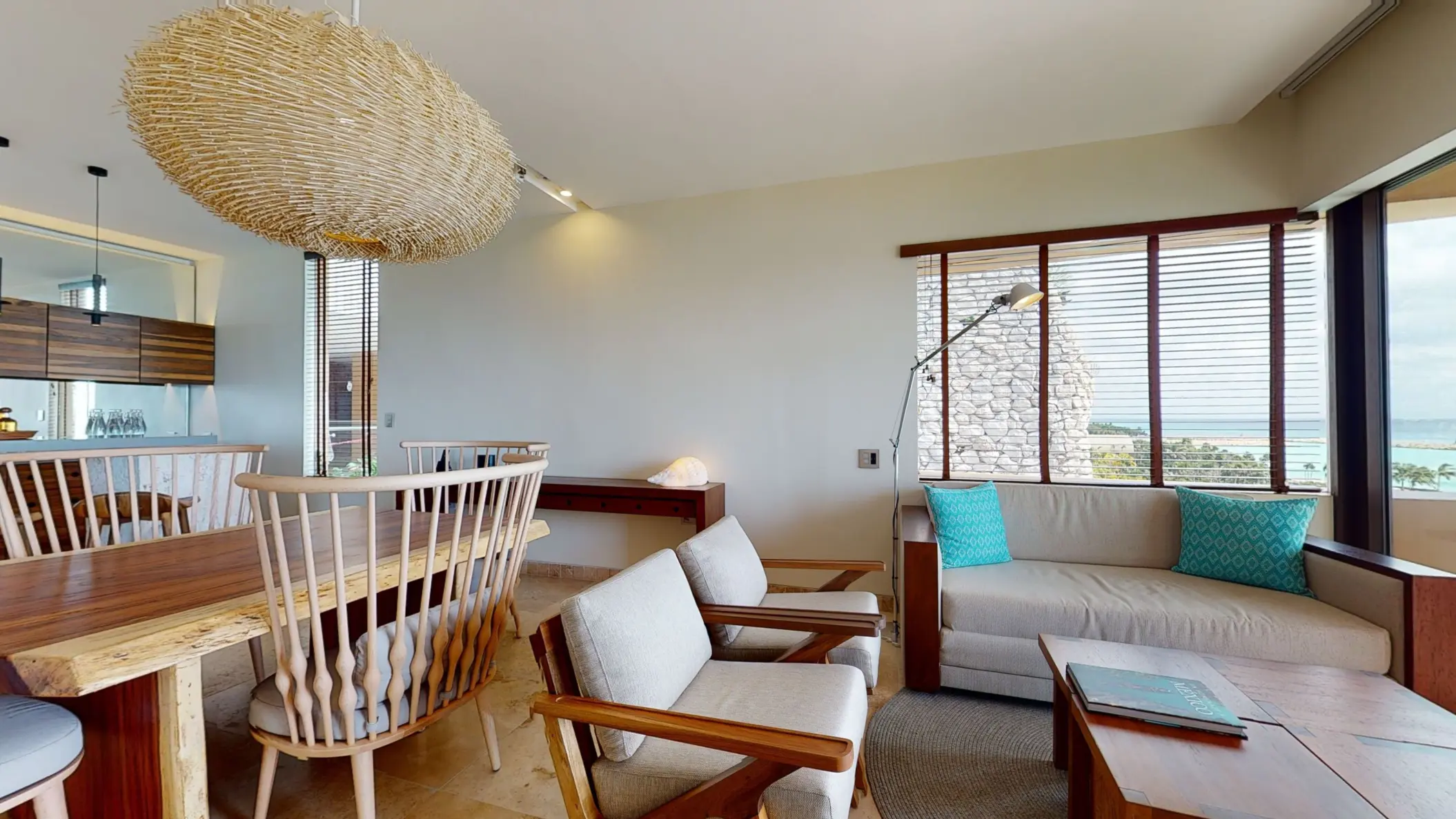 Open-concept living and dining room with ocean view, wooden furniture, and coastal-inspired modern design.