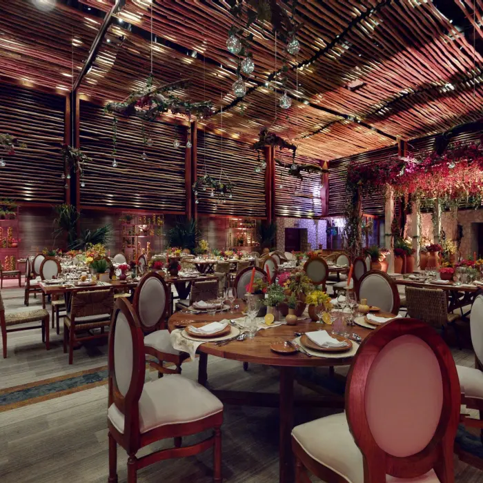 Lavish indoor wedding venue decorated with colorful florals and rustic wood design.