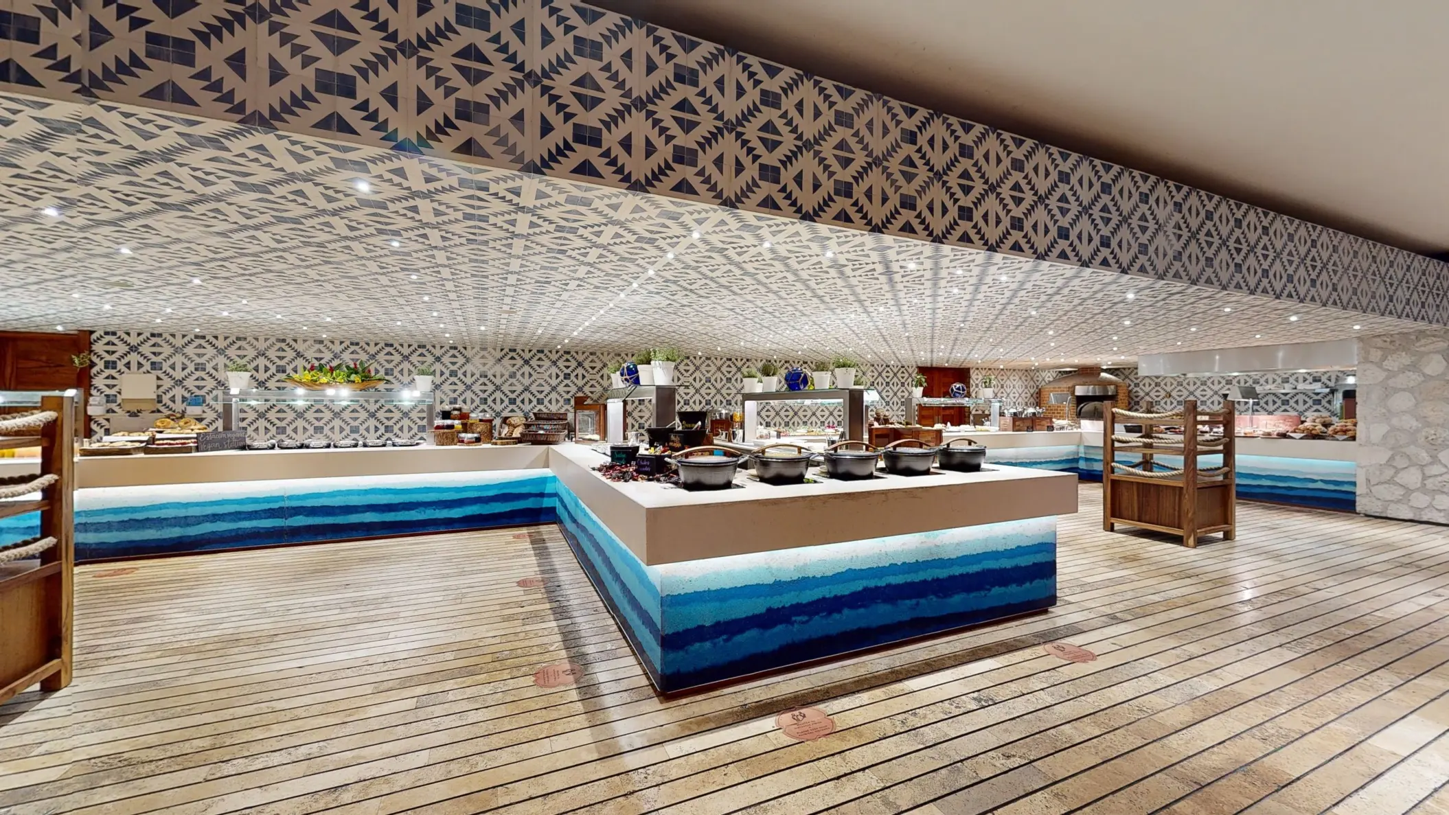 Wide view of Xcaret Arte’s vibrant buffet with geometric tile décor and blue-accented counters.
