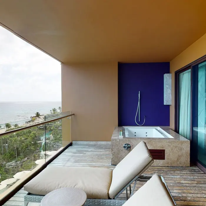 Oceanview balcony with lounge chairs and a private outdoor hot tub at Hotel Xcaret Arte.