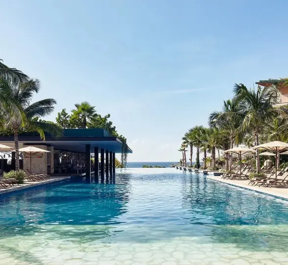 Hotel Xcaret Mexico pool and poolside loungers and resort buildings