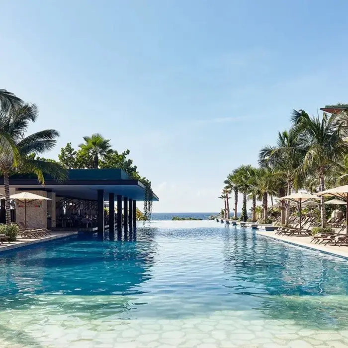 Hotel Xcaret Mexico pool and poolside loungers and resort buildings
