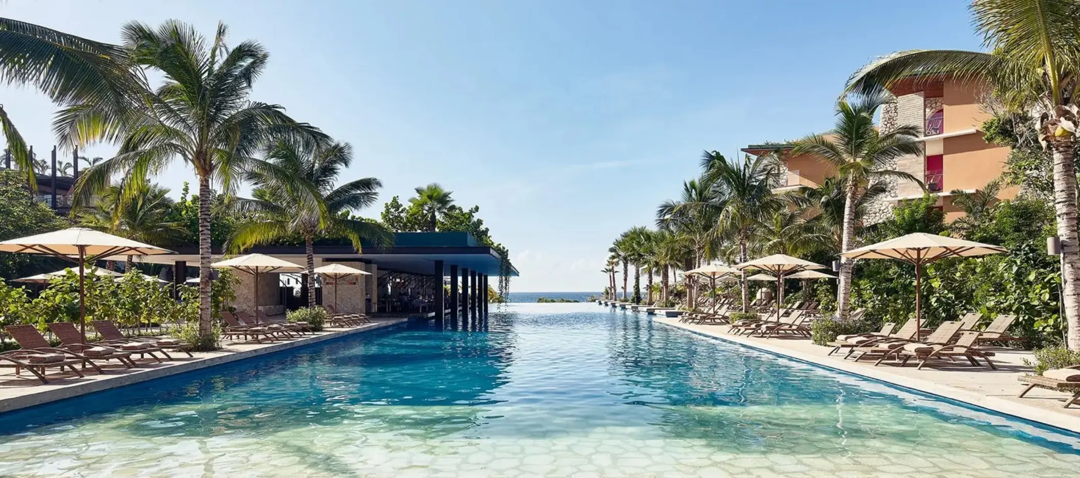 Hotel Xcaret Mexico pool and poolside loungers and resort buildings