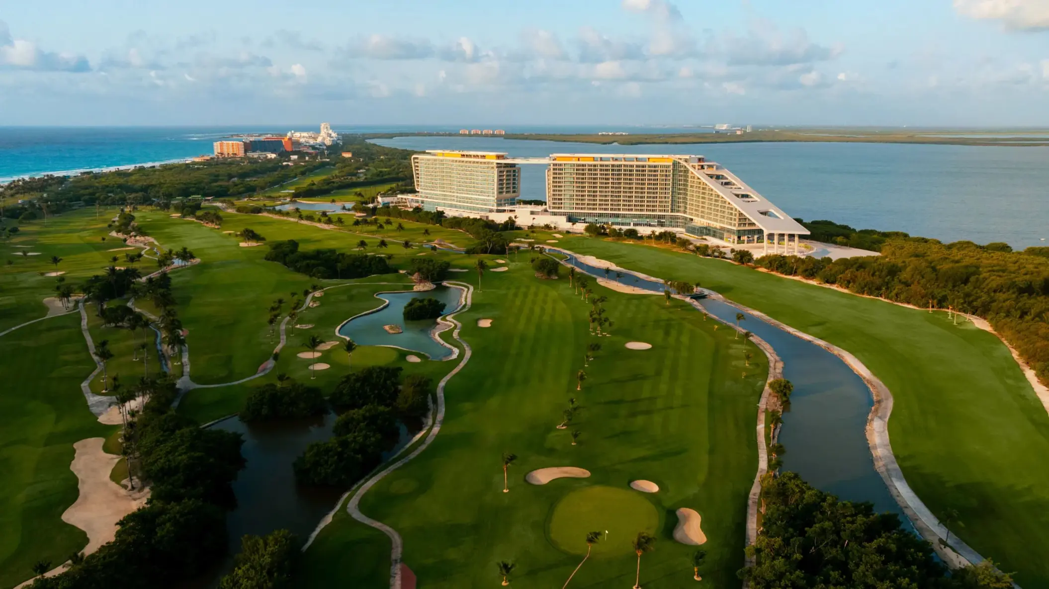 Aerial view of resort with expansive golf course, ocean views, and tropical landscapes in Cancun.
