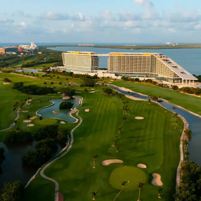 Aerial view of resort with expansive golf course, ocean views, and tropical landscapes in Cancun.