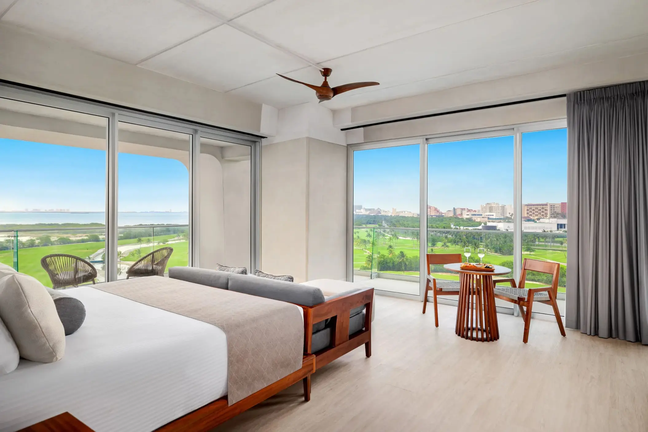 Elegant Vantage Club suite with king bed, warm lighting, and balcony overlooking golf course and jungle.