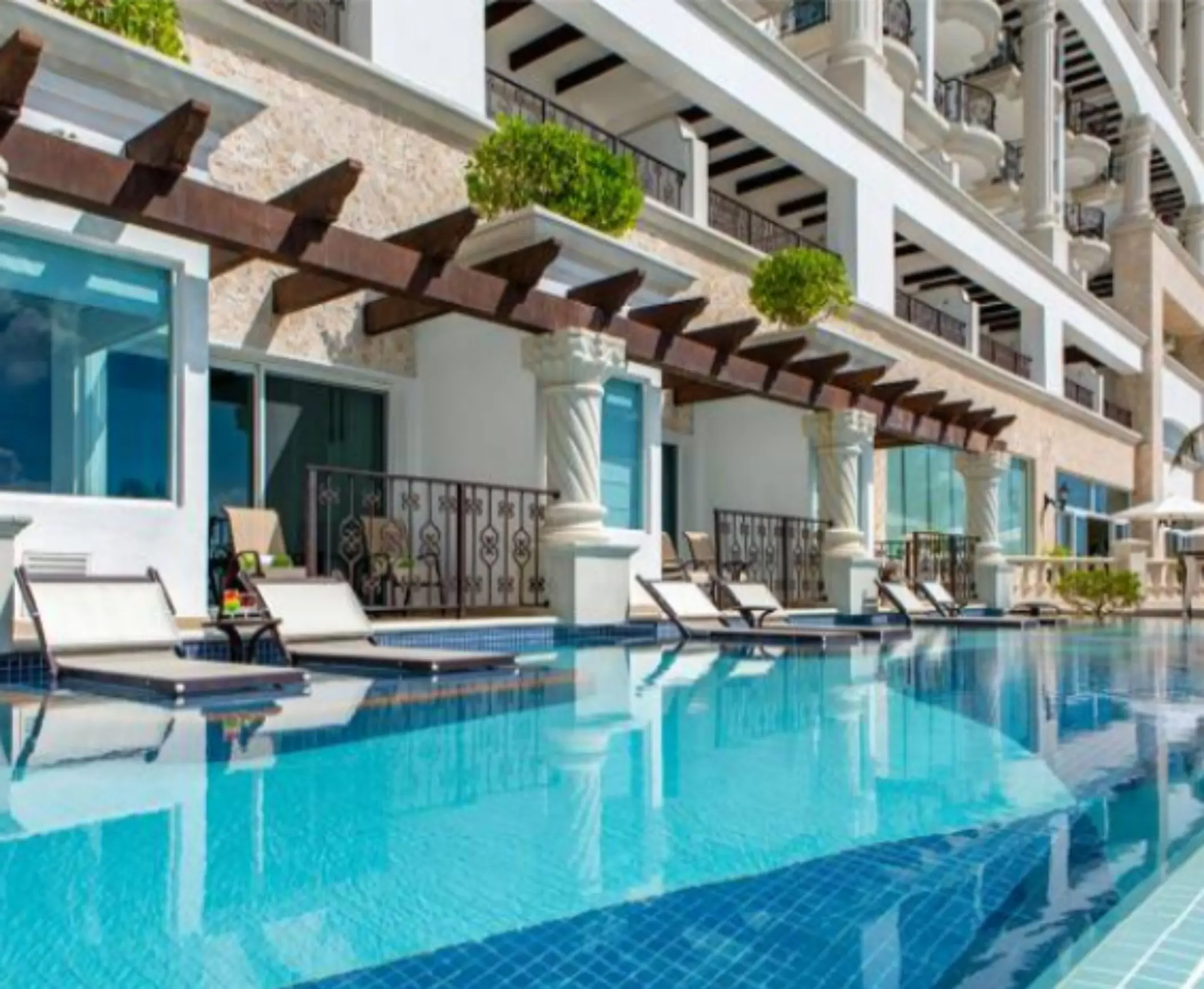 Swim-up suites with lounge chairs and direct access to the pool framed by spiral columns.
