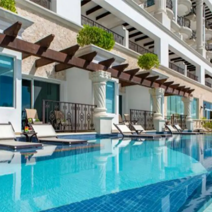 Swim-up suites with lounge chairs and direct access to the pool framed by spiral columns.